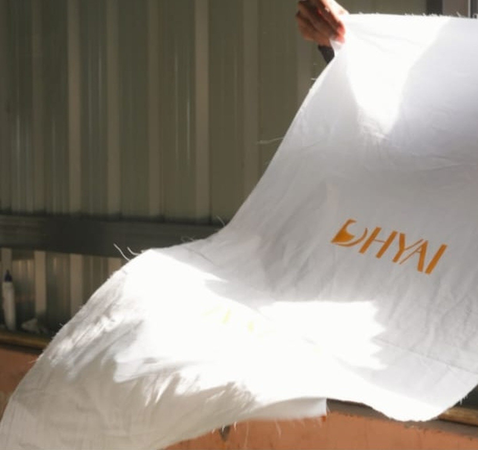 Hands lifting fabric in studio